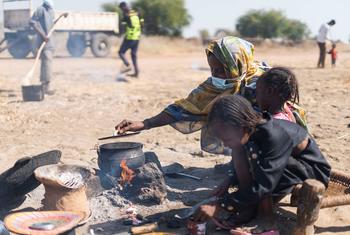 An internally displaced woman cooks in an open space in the El Ban Gadeed settlement in Sudan.