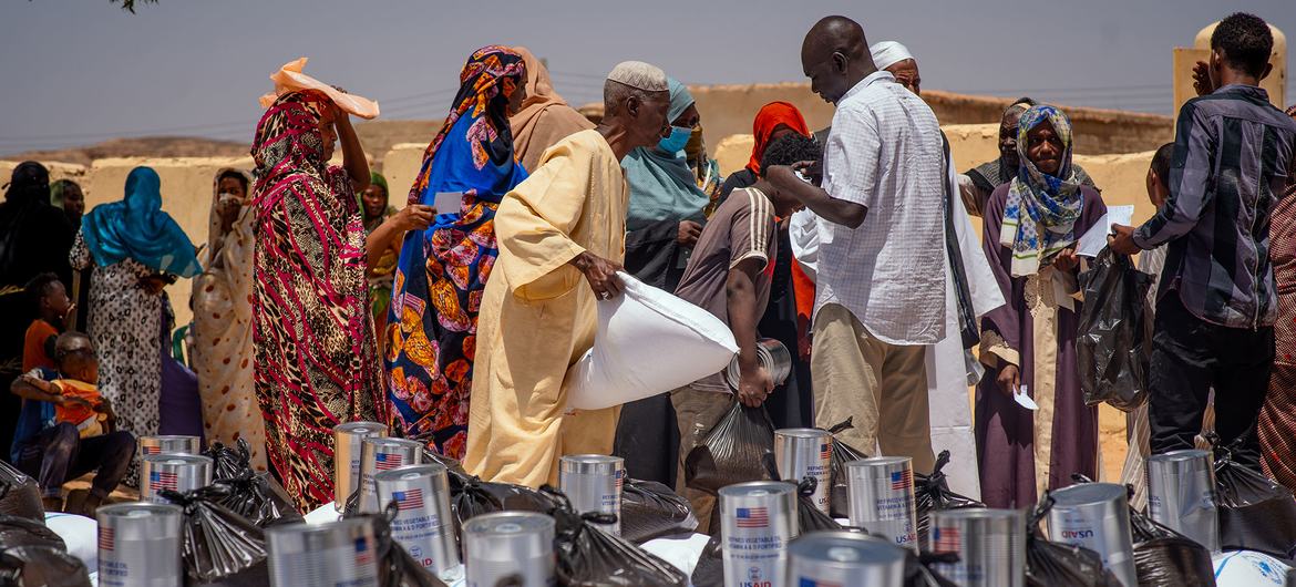 نازحون داخليا يتسلمون المؤن خلال توزيع المواد الغذائية في وادي حلفا، السودان.
