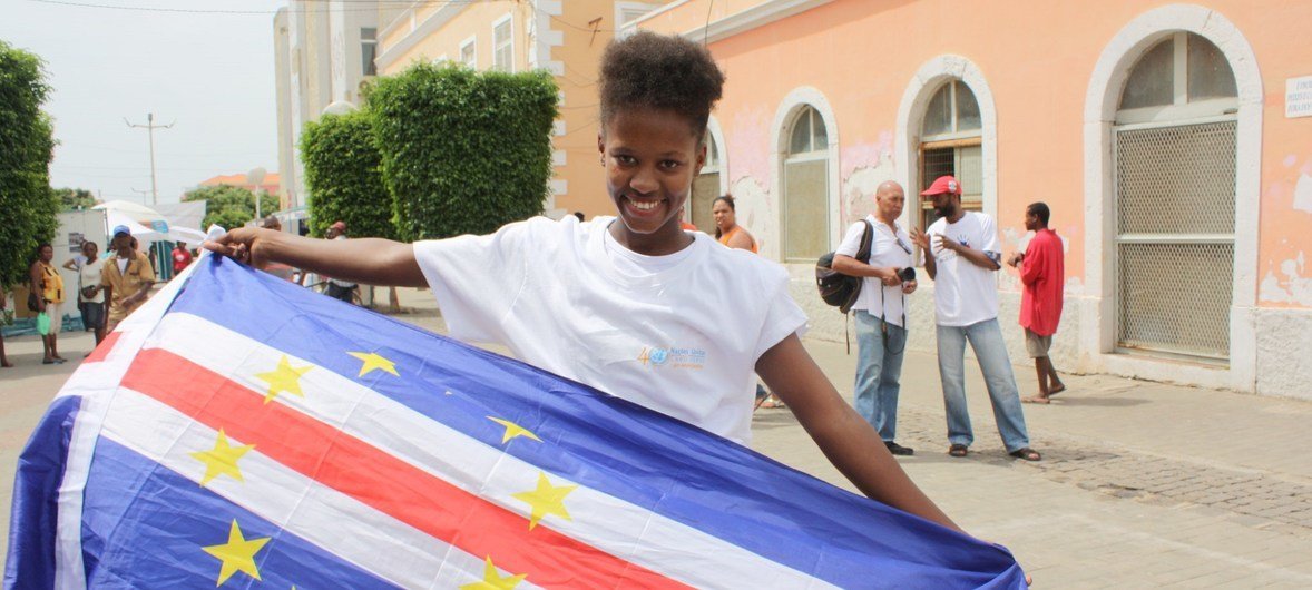 Jovem segura bandeira cabo-verdiana na cidade da Praia.
