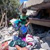 Мальчик на развалинах своего дома в Газе. 