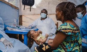 Binja, mtoto mwenye umri wa miezi 2 akiwa mikononi mwa mama yake, Mapenzi, anasajiliwa kabla ya ushauri wao wa kiafya mara tu wanapowasili katika kituo cha kutenga na kutibu wagonjwa wa mpox kinachosaidiwa na UNICEF katika Hospitali ya Kavumu, jimbo la K…