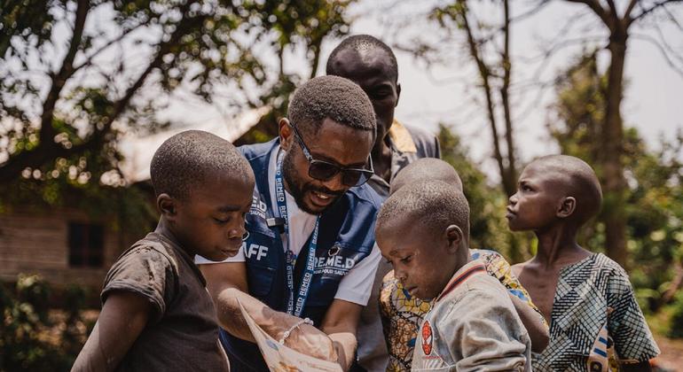 Msimamizi wa mradi anayeungwa mkono na UNICEF, Parfait Muhani, anawaelimisha watoto kuhusu kinga dhidi ya mbox katika kijiji kimoja huko DR Congo.