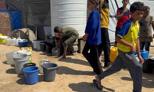 Children collect water in southern Gaza.