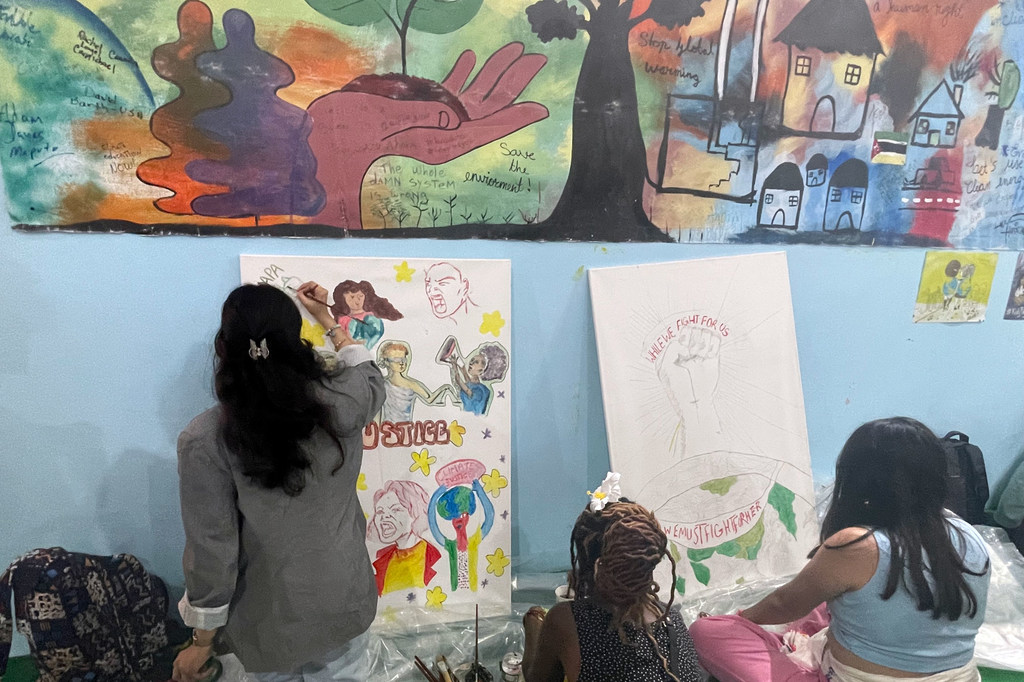 Ayshka Najib, militante pour le climat de l'UNICEF, peint une œuvre d'art collaborative au pavillon des jeunes à la COP27.