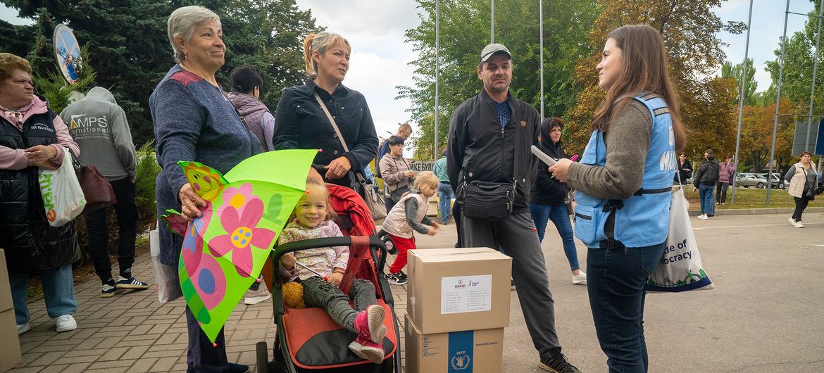 Viktoriya Hrubas (right) provides information to a family arriving at a humanitarian hub in Zaporizhzhia, after evacuating from Donetska Oblast in Ukraine.