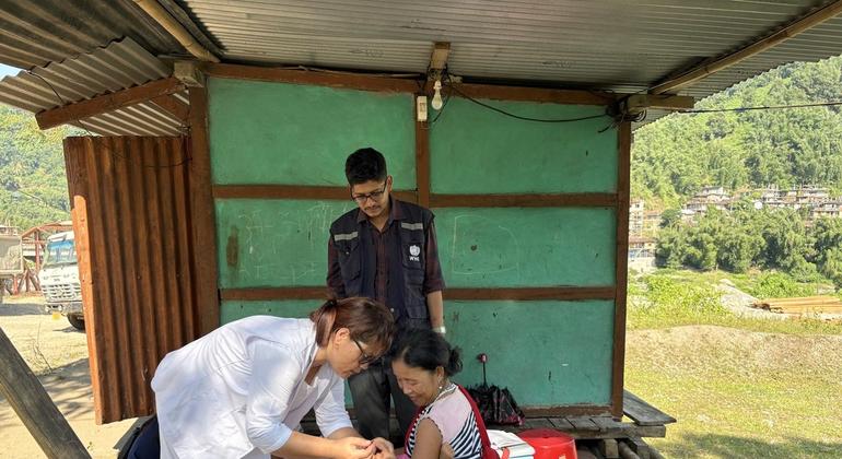 एक माँ अपने बच्चे का टीकाकरण करवाती हुई.