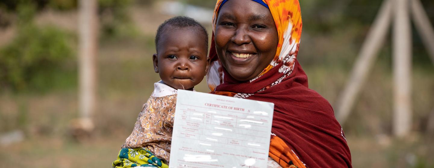 Une mère de la communauté de Pemba au Kenya est heureuse d'obtenir un certificat de naissance pour sa fille.