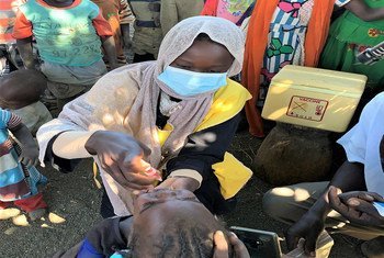 A health promoter is giving two-year-old Munasa Muhyadin, her polio vaccine in Gorlangbang in South Jebel Marra.