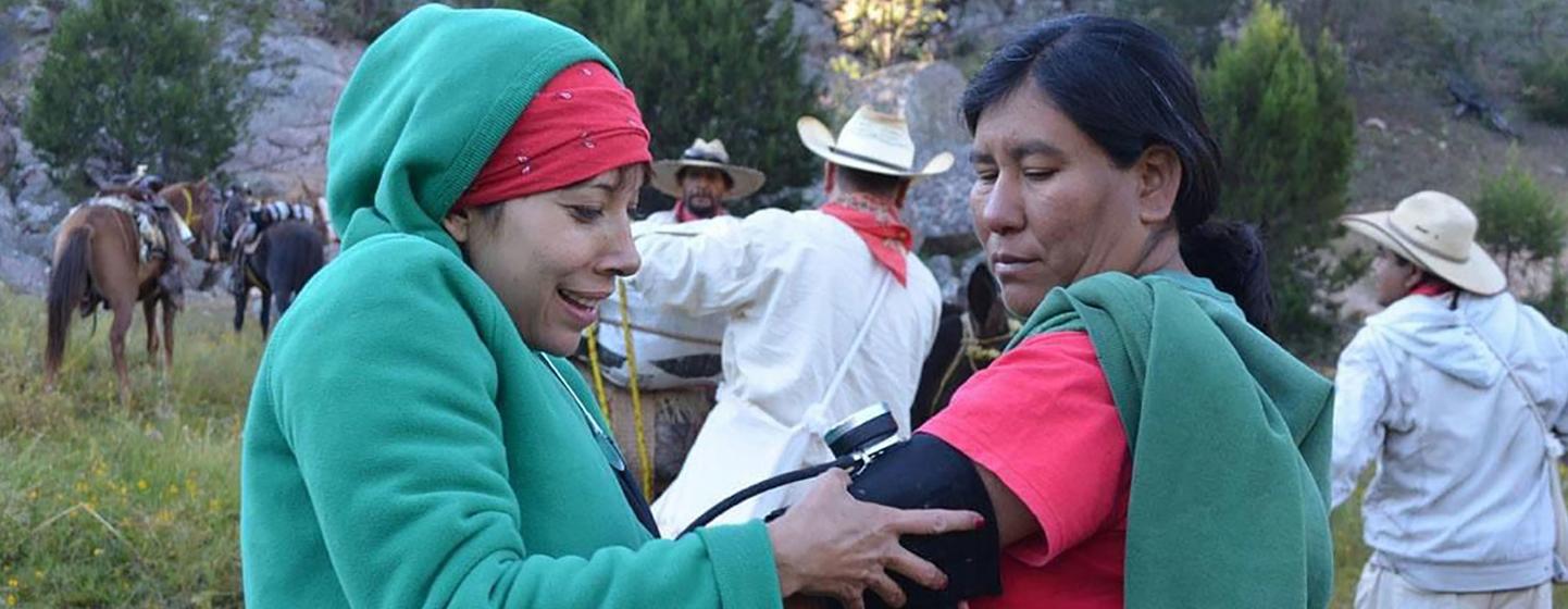 Julia Paredes le toma la presión arterial a una mujer indígena en la sierra.