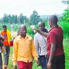 Mfanyakazi wa afya wa Shirika la Afya Duniani aliyevaa shati jekundu na barakoa ya uso anatumia kipimajoto cha infrared kumchunguza mwanamume aliyevaa shati la njano wakati wa mwitikio wa mlipuko huko Kagera, Tanzania.