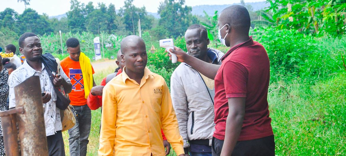 A health worker checks people's temperatures in the Kagera region of Tanzania. A health worker checks people's temperatures in the Kagera region of Tanzania.