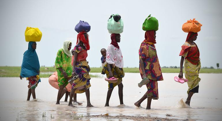 नाइजीरिया के बोर्नो राज्य में, जल-स्रोत के बीच से गुज़रती महिलाएँ.