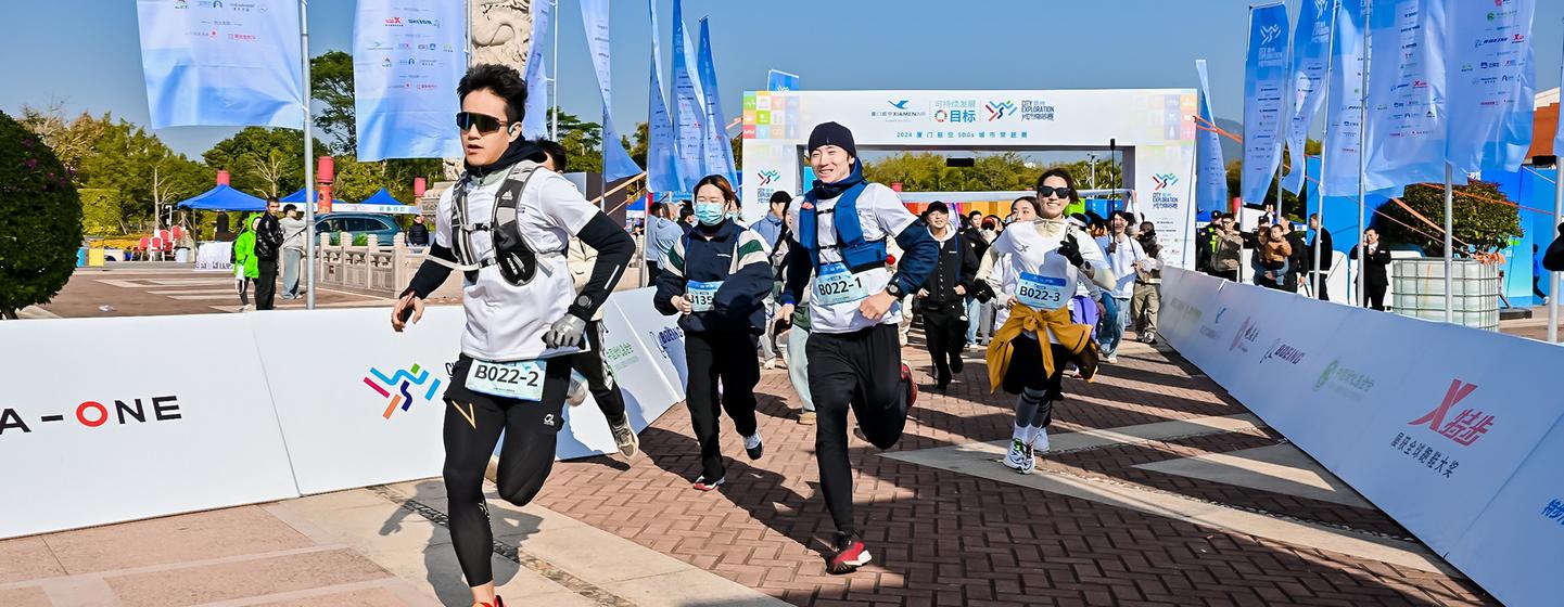 阳光明媚的日子里，跑步者们在厦门城市探索活动中冲过终点线。
