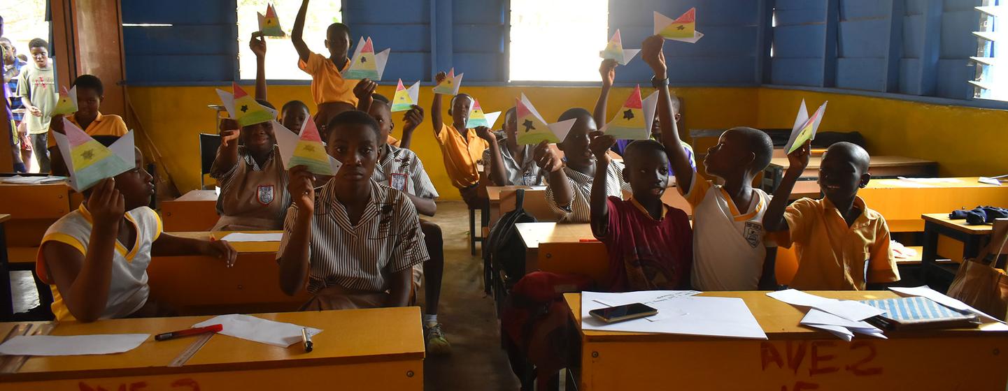 Alumnos de la escuela secundaria Avenida de la Independencia de Accra, Ghana, sostienen colibríes de origami, como parte de la campaña del Día Mundial del Agua 2023. 