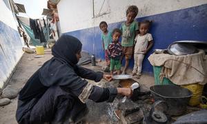 Une mère de neuf enfants souffrant de malnutrition prépare un repas pour ses enfants dans un camp de personnes déplacées à Aden, au Yémen.