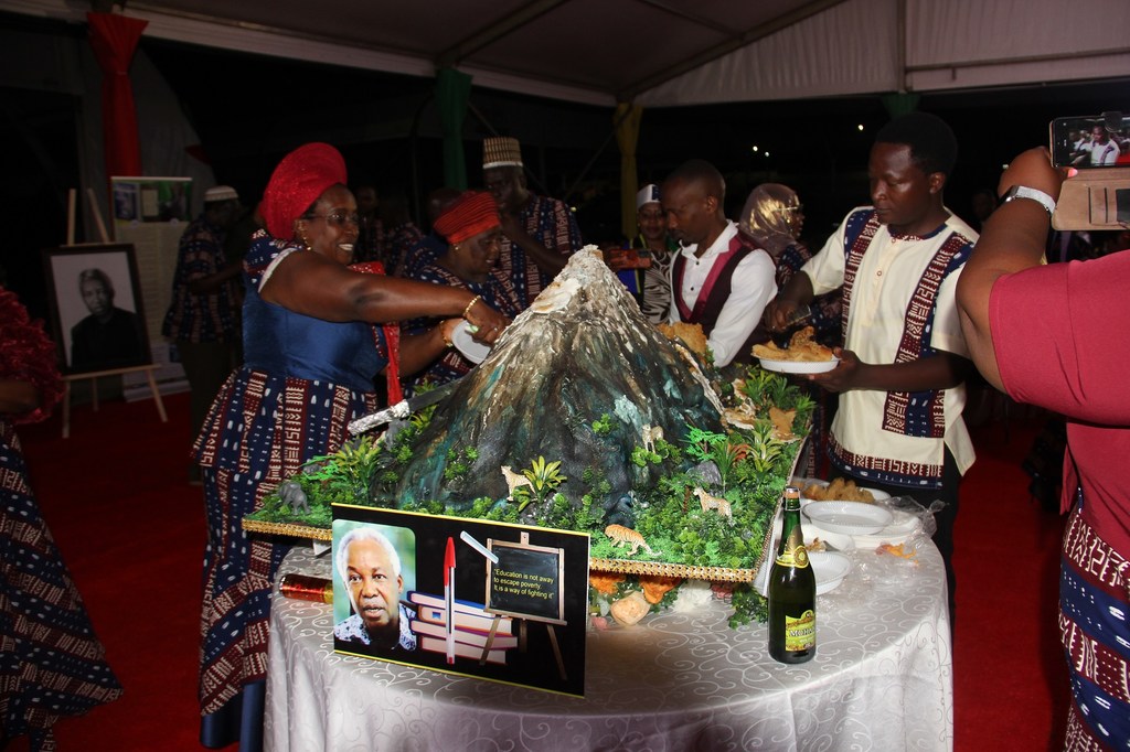 Kundi la watu waliovalia mavazi ya kitamaduni ya Uganda wakikata keki katika mkutano wa Kiswahili nchini Uganda.
