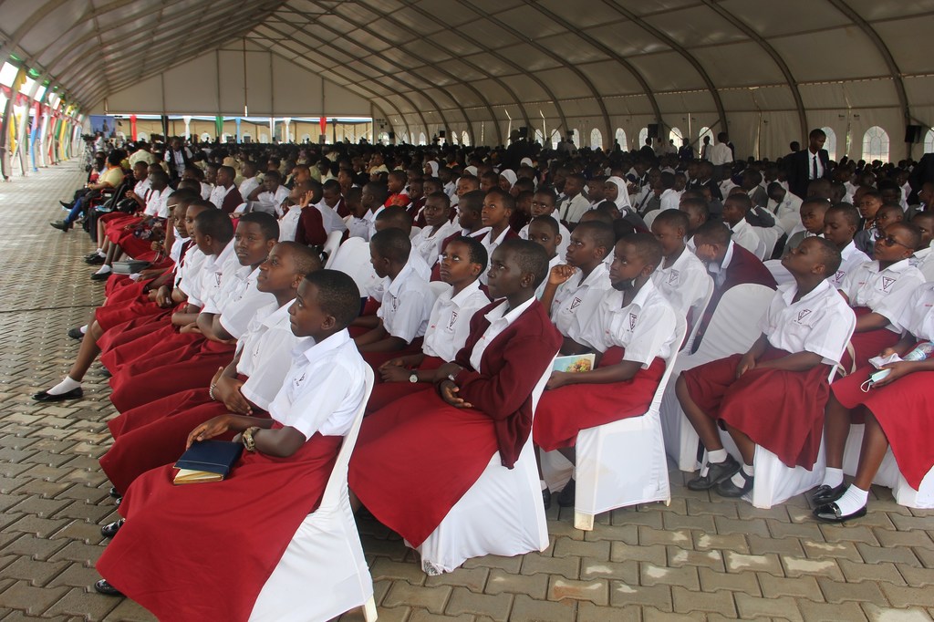 Kundi kubwa la wanafunzi wa shule za Uganda waliovaa sare nyeupe na nyekundu wameketi kwenye safu ndani ya hema katika Mkutano wa Kiswahili.
