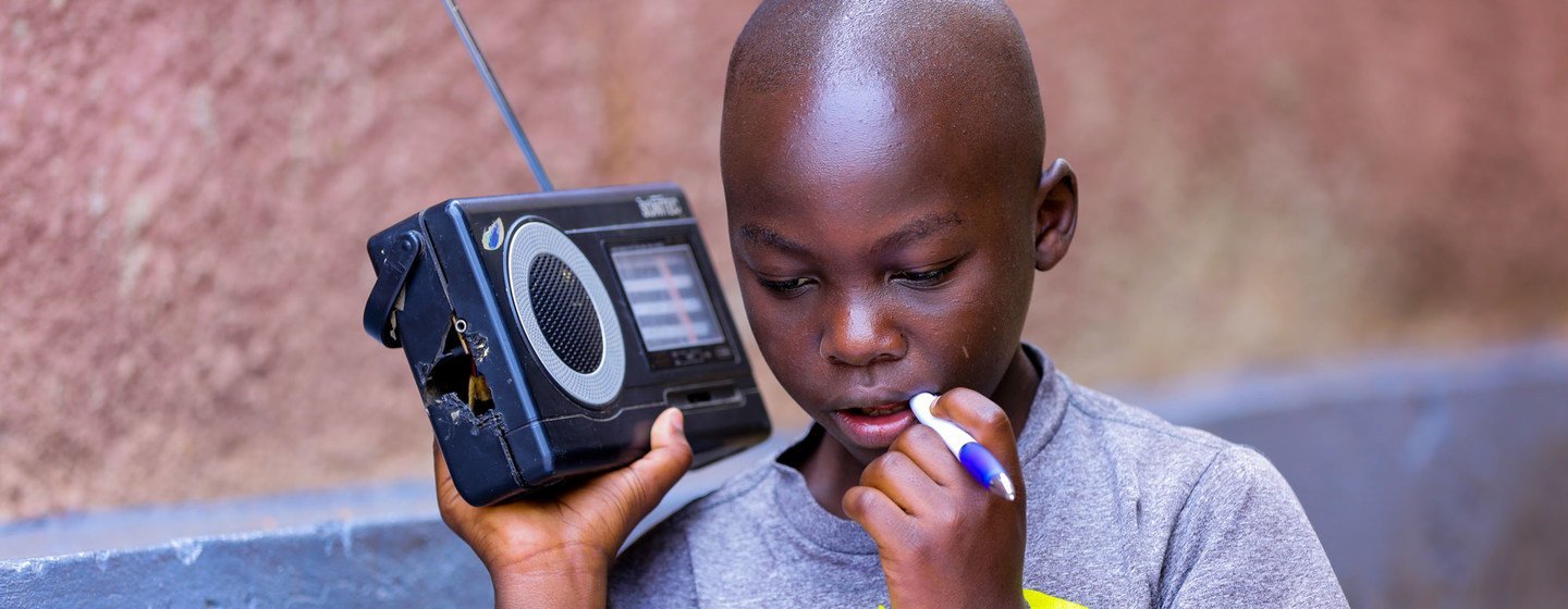 Un niño en Ruanda, identificado como Igihozo Kevin, de 11 años, escucha sus lecciones de Primaria 5 en una radio mientras estudia en casa debido al cierre de las escuelas causado por la pandemia de coronavirus.