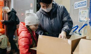 A mother and daughter from Chernihiv, Ukraine, unpack a box of new clothes, distributed by UNICEF and partners in Moldova.