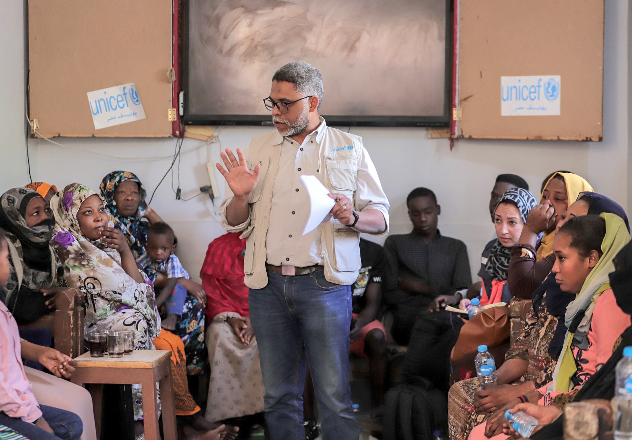 ممثل عن منظمة اليونيسف في مصر يتحدث مع أسر سودانية،  في إحدى جلسات الإرشاد النفسي بنادي الأسرة للسودانيين بموقف كركر الدولي بأسوان.