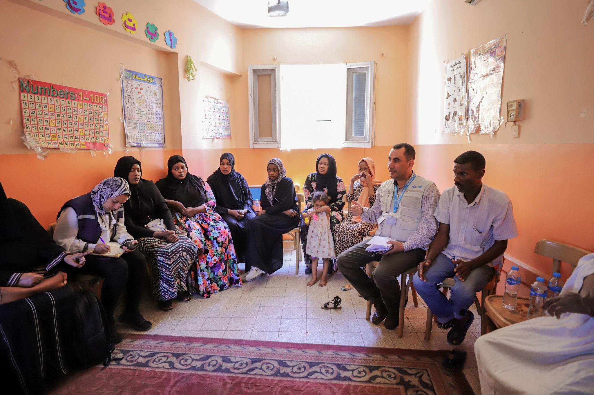 أيمن محارب، ممثل عن منظمة اليونيسف في مصر يتحدث مع أسر سودانية،  في إحدى جلسات الإرشاد النفسي بنادي الأسرة للسودانيين بموقف كركر الدولي بأسوان.