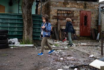 Unos niños caminando junto a una casa destruida en Kherson, Ucrania.