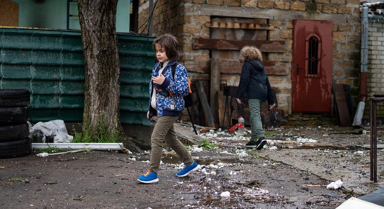 Unos niños caminando junto a una casa destruida en Kherson, Ucrania.