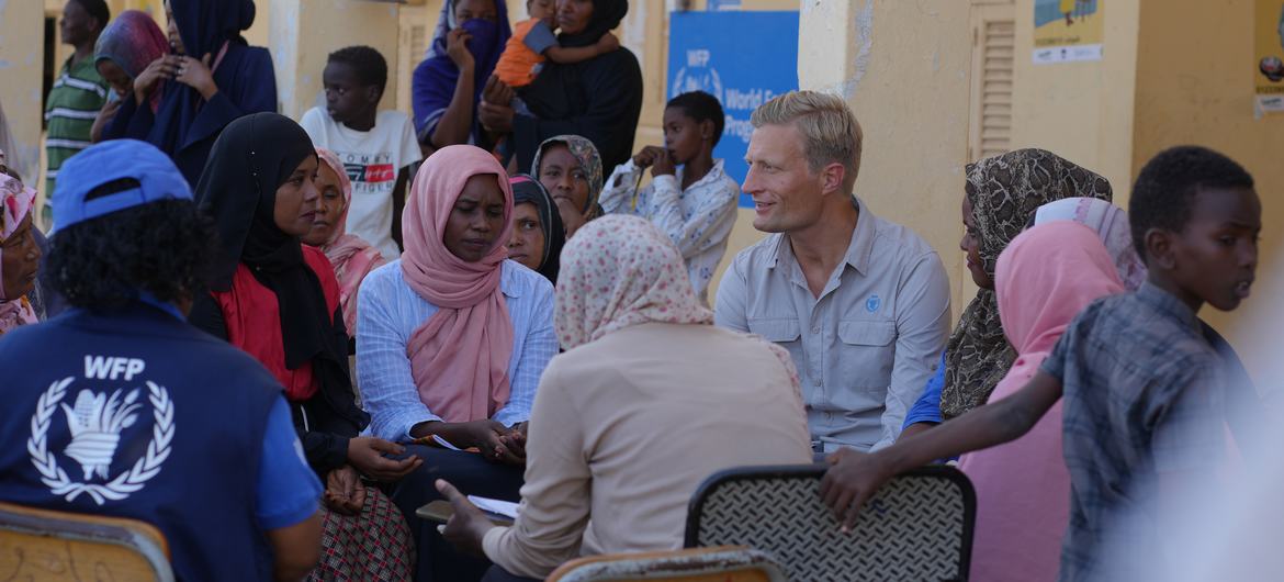 يتحدث نائب المدير التنفيذي WFP، كارل سكو، مع العائلات النازحة في مدرسة العشي في بورتسودان، السودان.