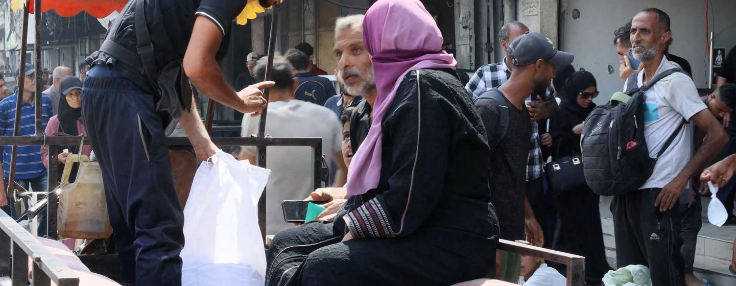 Umm Haytham Al-Kulak sits in a three-wheeled motorcycle trailer on her way back to her family.