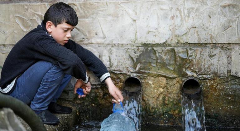 Um menino de 11 anos coleta água de um poço em Wadi El Jamous, no Líbano