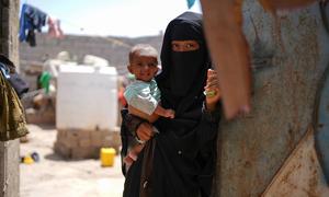A mother holds her child near their home in the Al Adani neighbourhood of Al Hawtah, Yemen.