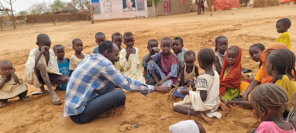 Anwar Khatir de l'ONG Wadi Hawar joue avec des enfants dans le camp de déplacés de Zam Zam.