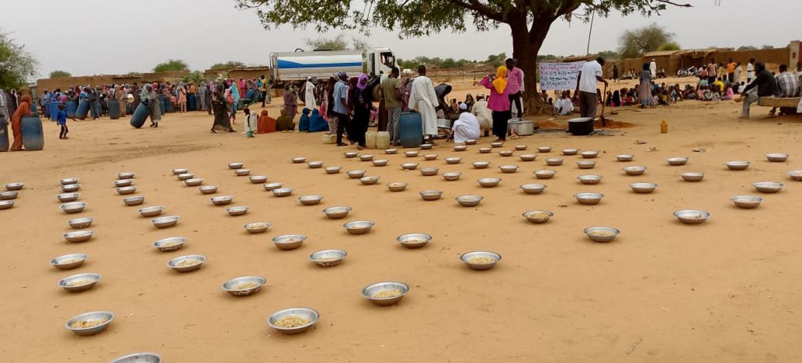 Las familias se reúnen para disfrutar de una comida preparada y proporcionada por los equipos de la sala de respuesta a emergencias del campamento de Zamzam en el norte de Darfur.