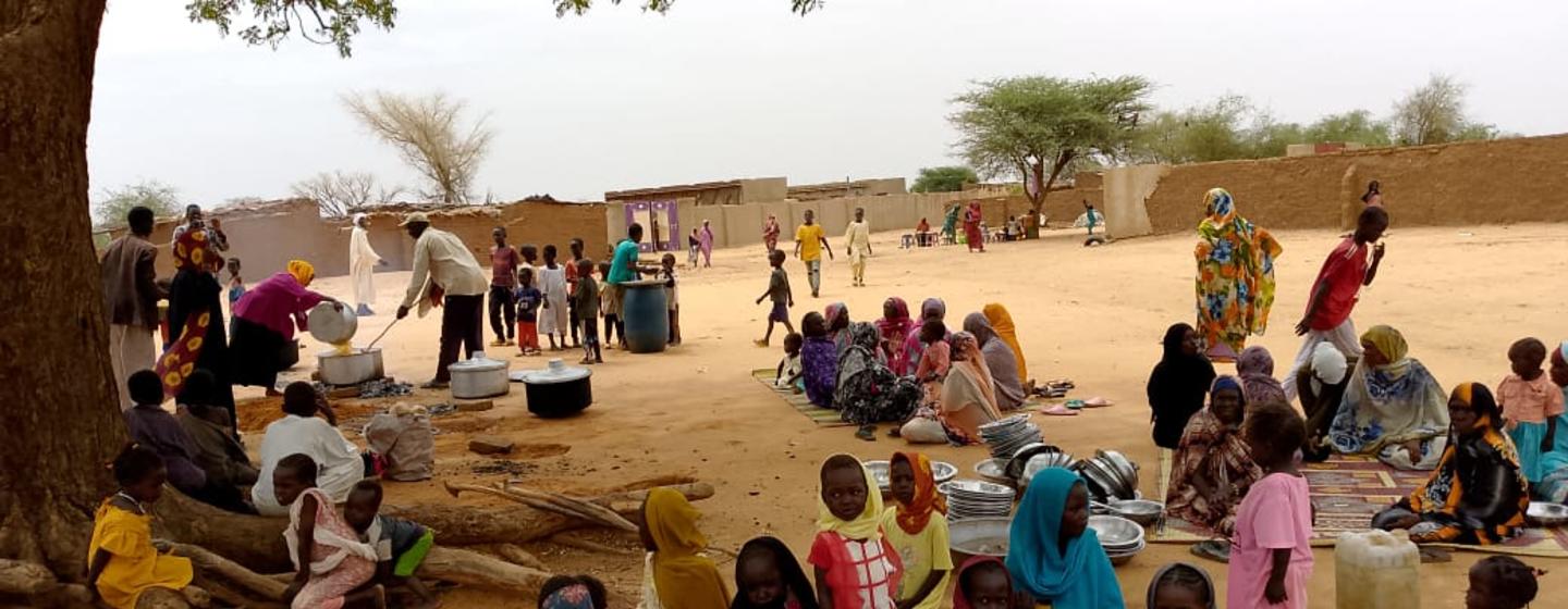 Des familles du camp de Zamzam se rassemblent pour recevoir un repas fourni par la salle d'intervention d'urgence du camp.