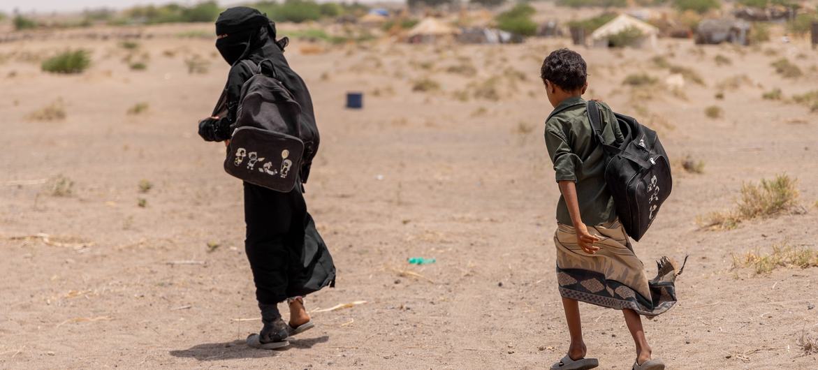 A girl and her brother walk home after attending classes at a UNICEF-supported educational tent. Millions of children in Yemen are out of school due to displacement and conflict-damaged schools. (file photo)
