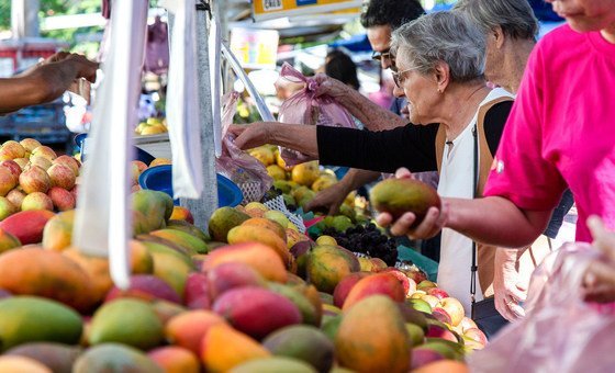 ब्राज़ील के साओ पाउलो में स्थित एक बाज़ार में ग्राहक आम व अन्य फ़लों की ख़रीदारी कर रहे हैं.