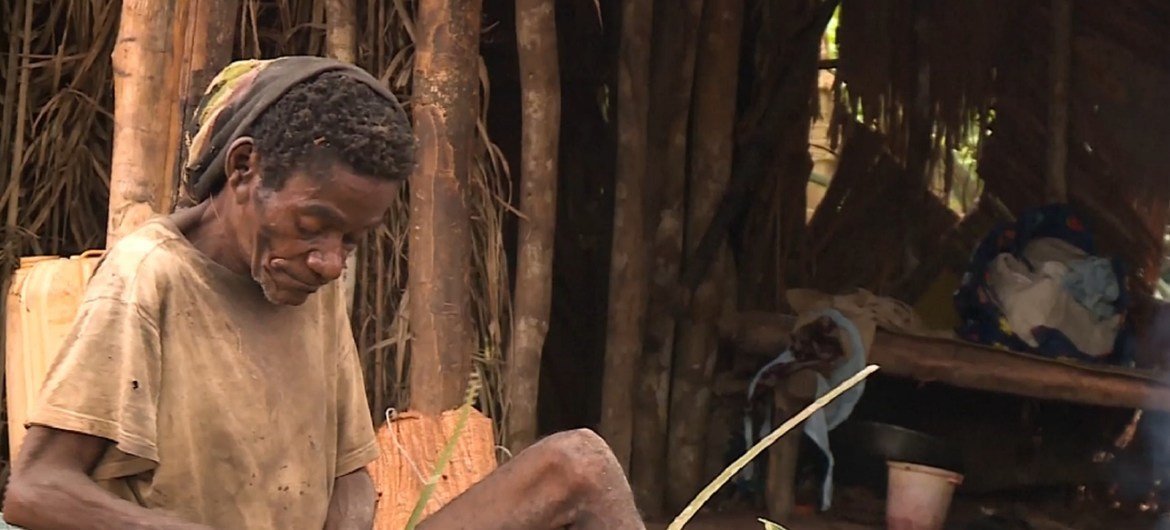Um idoso tece folhas de palmeira em uma casa rural no Congo Brazzaville.