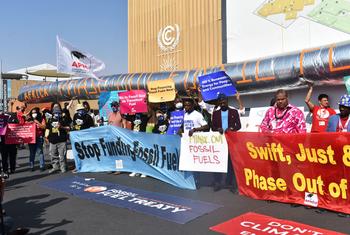 कॉप27 सम्मेलन के आयोजन स्थल के बाहर प्रदर्शनकारी, अफ़्रीका में तेल एवं गैस परियोजनाओं के विस्तार का विरोध कर रहे हैं.