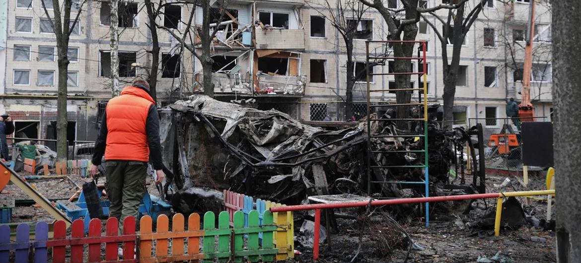 A resident stands in front of his apartment building in Kyiv which was in an overnight strike in December 2023.