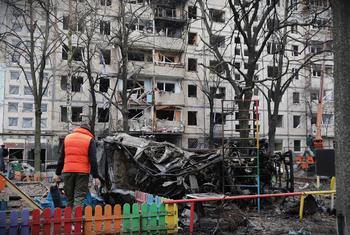 यूक्रेन की राजधानी किएव में एक व्यक्ति अपनी आवासीय इमारत के पास, जिसे दिसम्बर 2023 में हुए एक आक्रमण में, भारी नुक़सान पहुँचा.