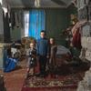 तीन भाई-बहन, यूनीसेफ़ द्वारा उपलब्ध कराए गए कपड़ों में फोटो खिंचा रहे हैं