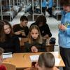 Uma professora vestindo uma jaqueta azul da Unicef dá aula para um grupo de alunos em uma sala de aula com beliches em Kharkiv, na Ucrânia.