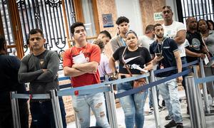 Venezolanos hacen cola en la oficina de migración de Lima, Perú.