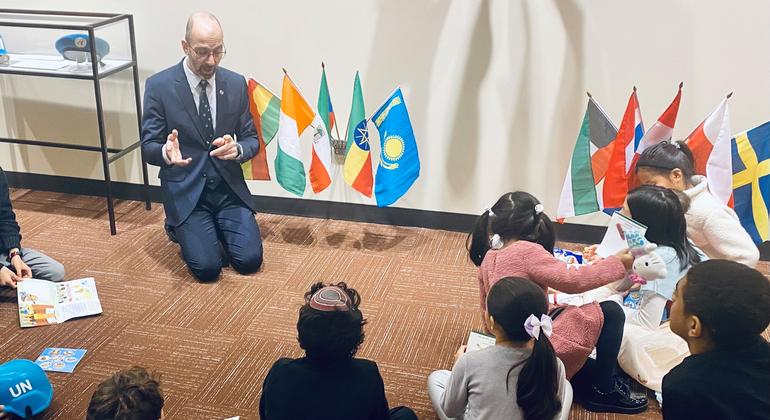 UN guide Jonathan Mishal explains the UN to a group of young children.