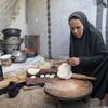 Une femme prépare du pain dans sa tente à Gaza.