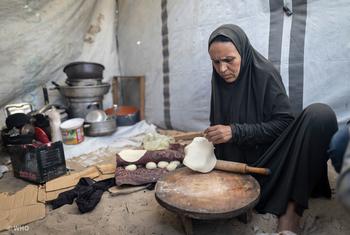 Une femme prépare du pain dans sa tente à Gaza. Une femme prépare du pain dans sa tente à Gaza.