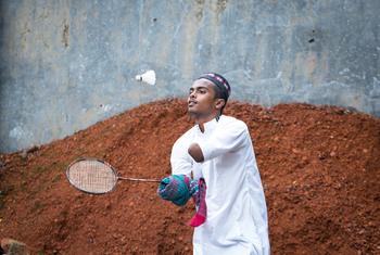 A disabled teenage boy plays badminton in front of his house in Bangladesh.