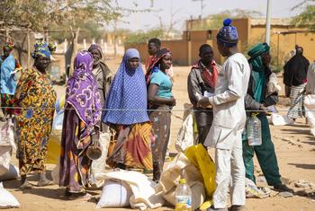 أشخاص نازحون ينتظرون في طابور توزيع الطعام عليهم في بوركينا فاسو.