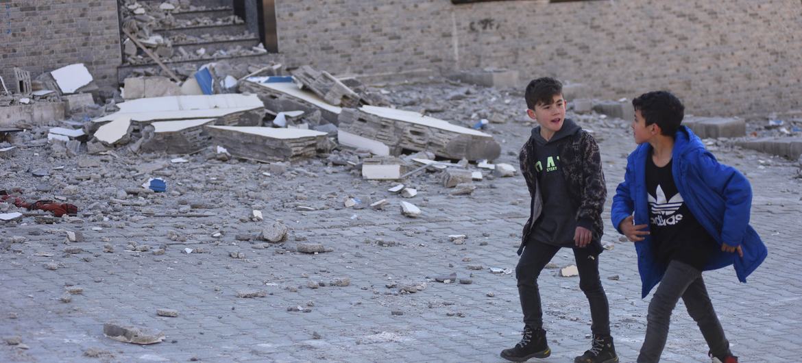 Two boys walk through the earthquake damaged streets of Kahramanmaraş, Türkiye.