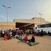 People fleeing conflict in Sudan wait at a bus station in Khartoum.
